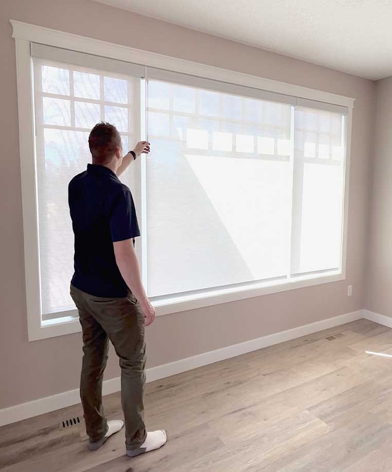 A man testing his honeycomb shades